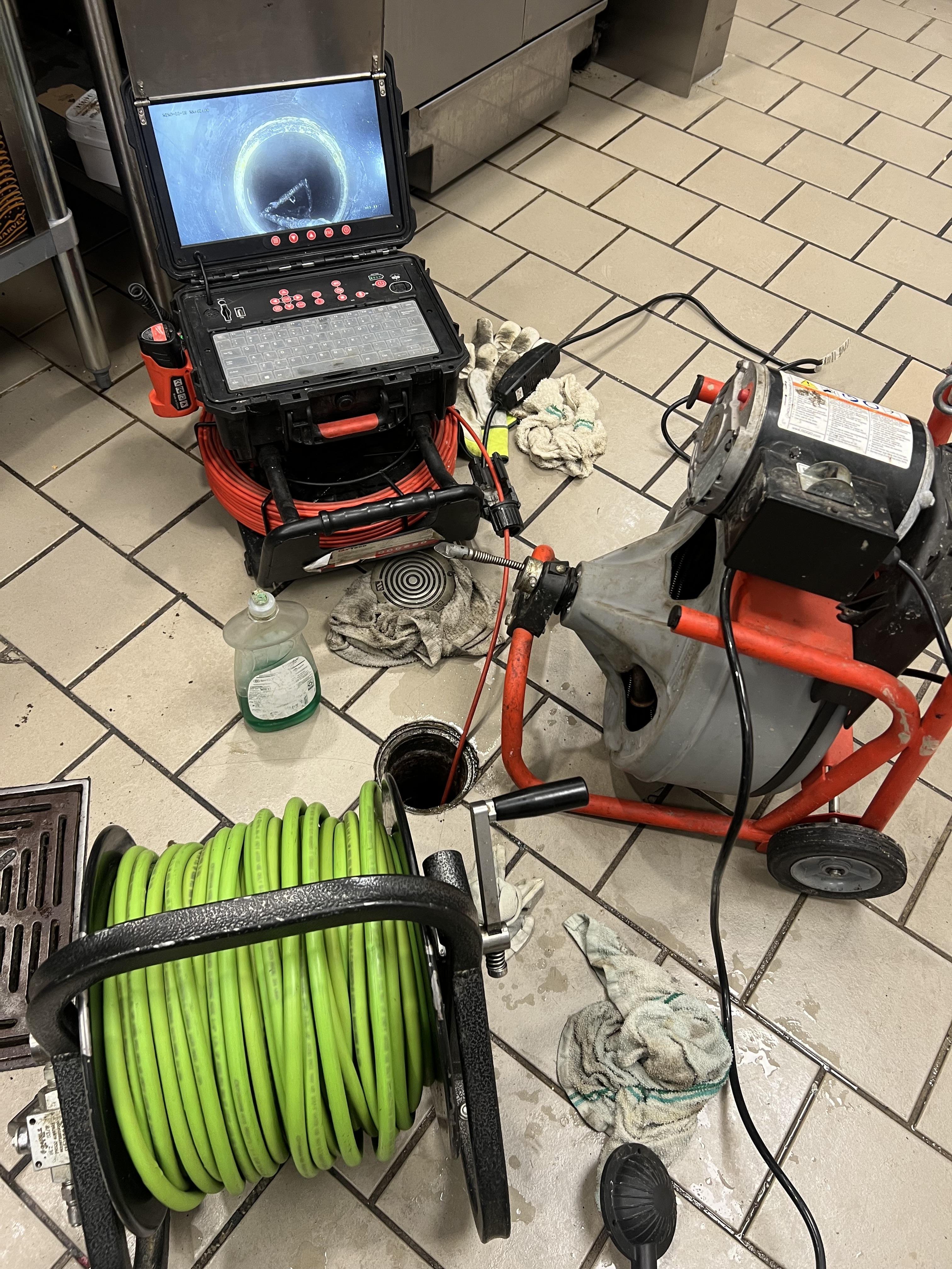 GDM Vac hoses routed to an exterior access panel during an emergency trap clean